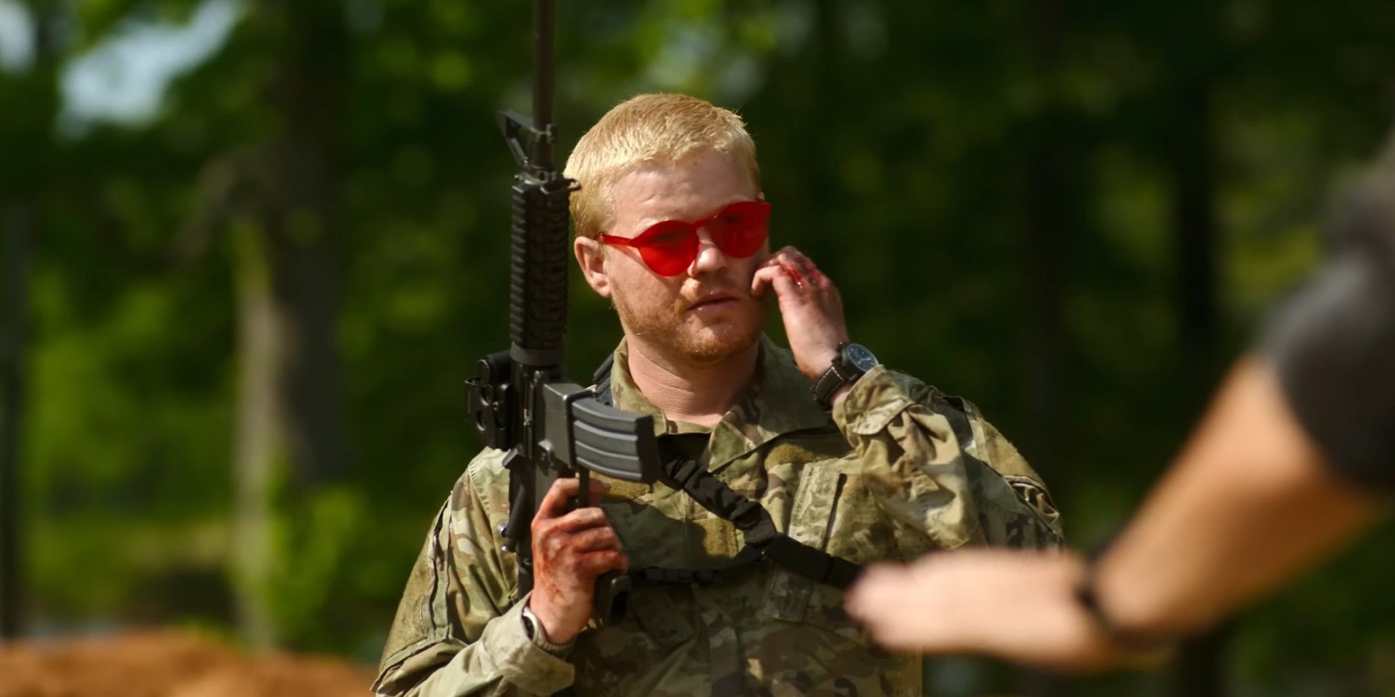 Jesse Plemons in red sunglasses and fatigues holding a gun in the trailer for Civil War