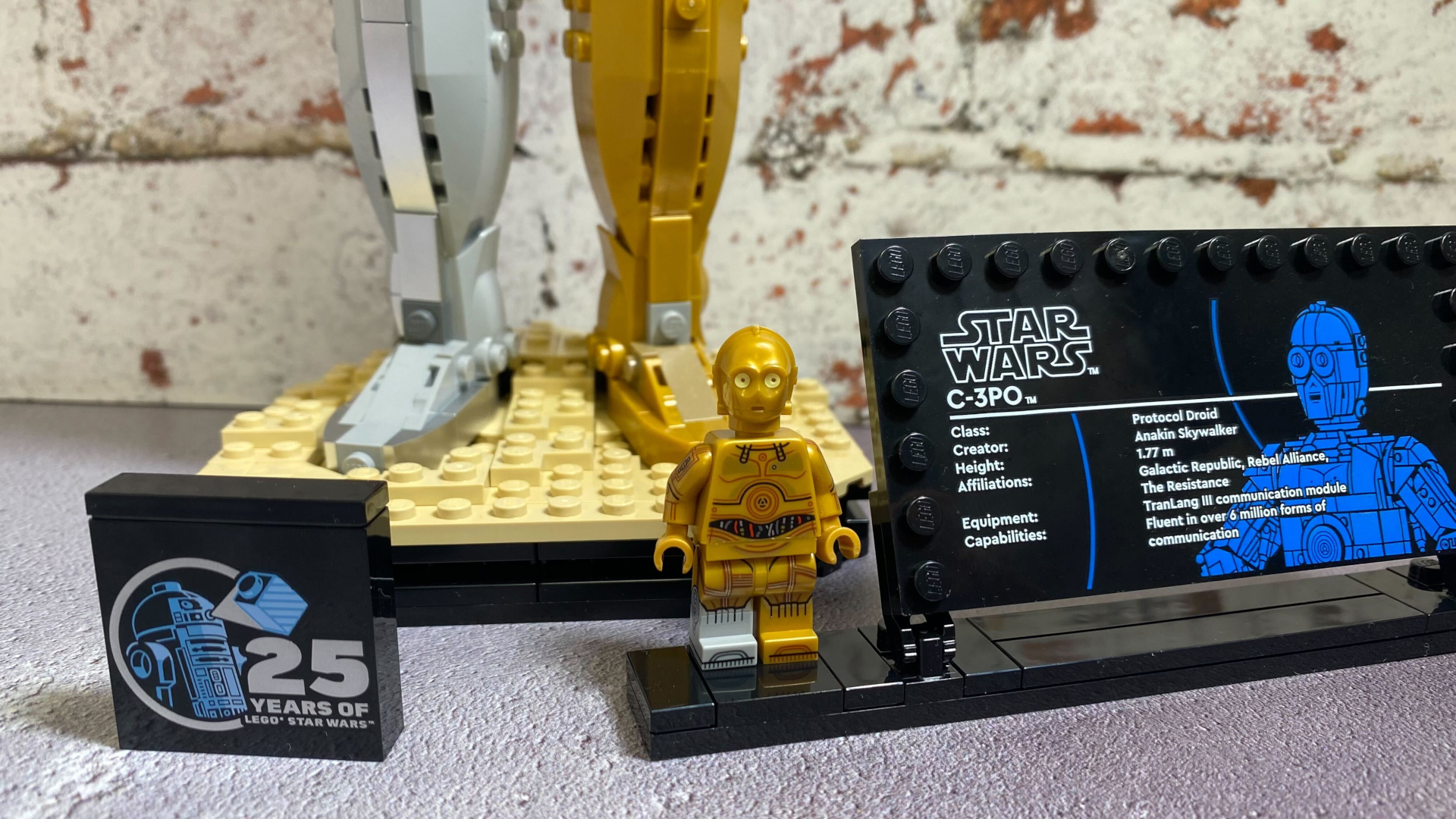 Lego C-3PO minifigure on a plaque, in front of the main model