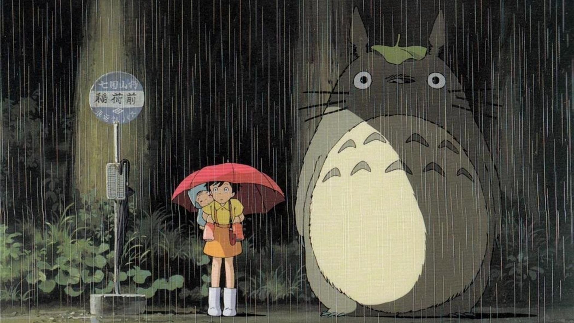 Satsuki and Mei standing in the rain at a bus stop next to a totoro in My Neighbor Totoro