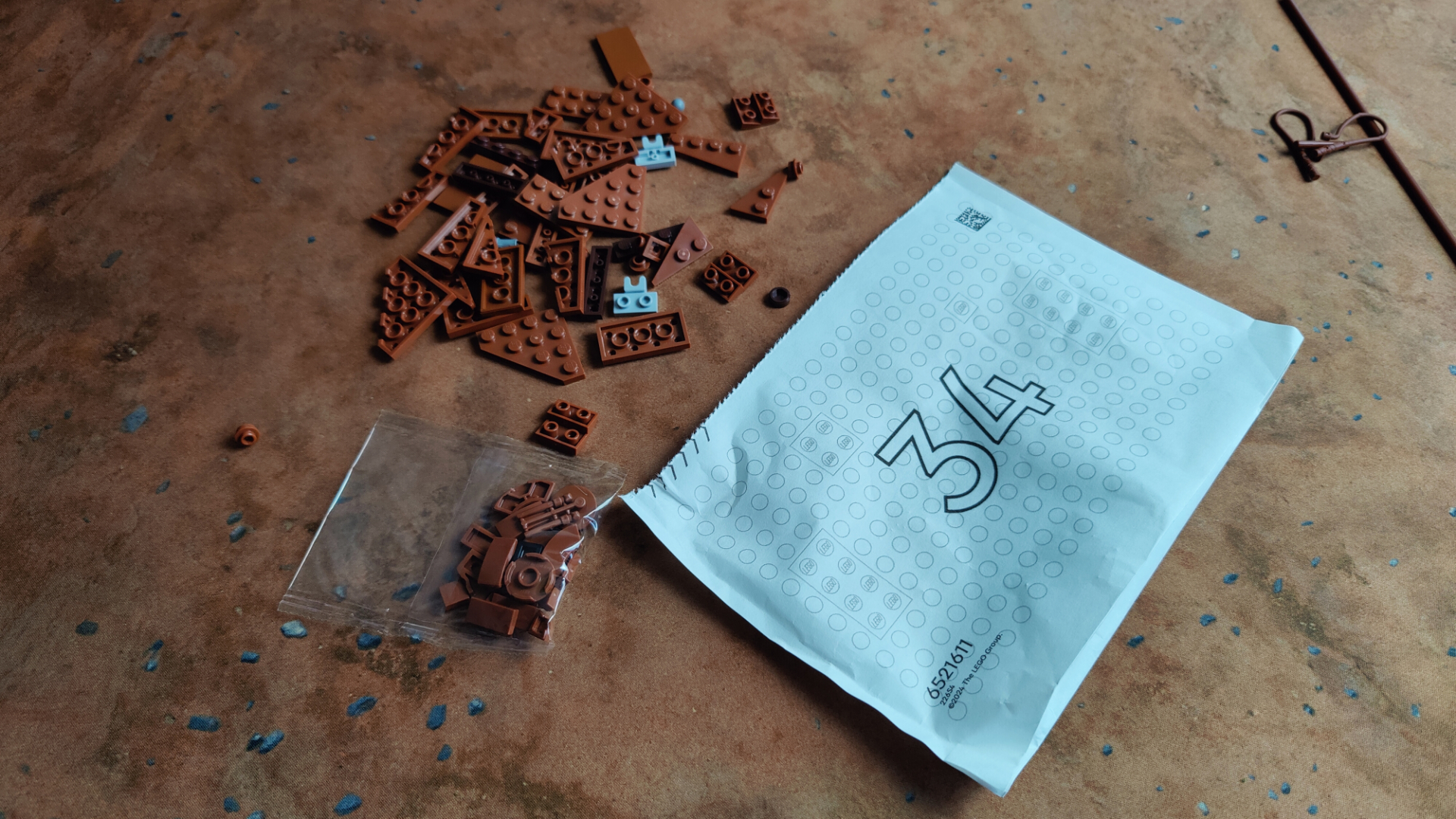 Lego Jabba's Sail Barge pieces and parts bag laid out on a desert mat