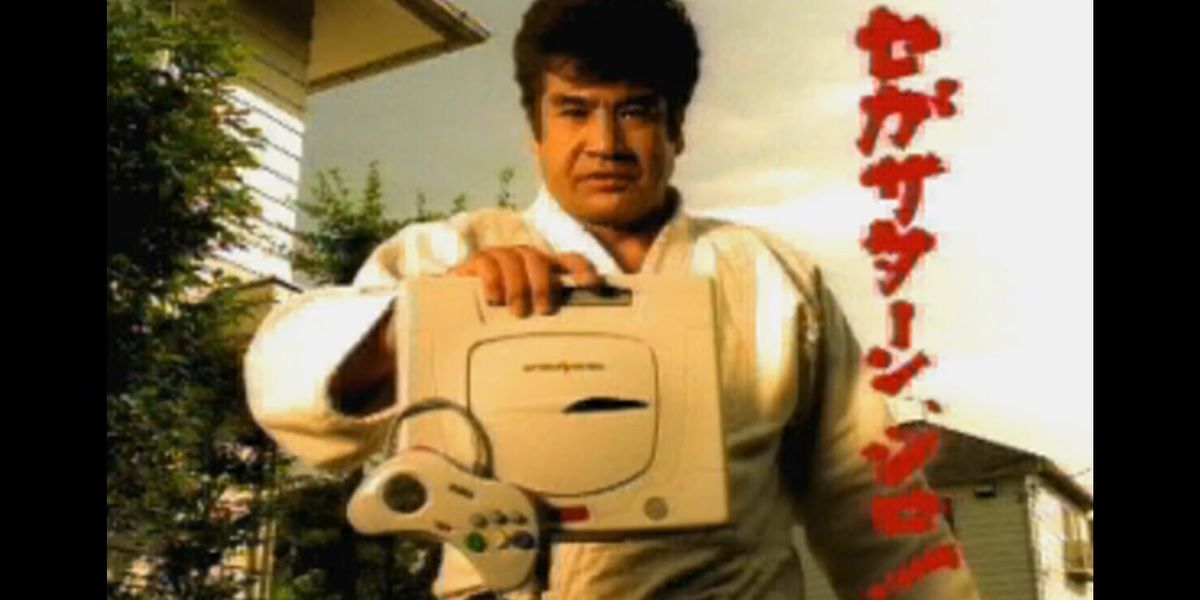 Segata Sanshiro holds out a Sega Saturn console while the onscreen text reads, "Play Sega Saturn,' in Japanese.