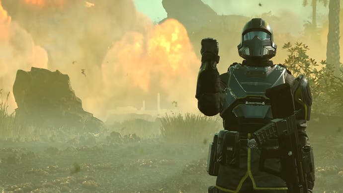 Helldivers 2 player with a clenched fist in front of explosions and fire in the vein of 