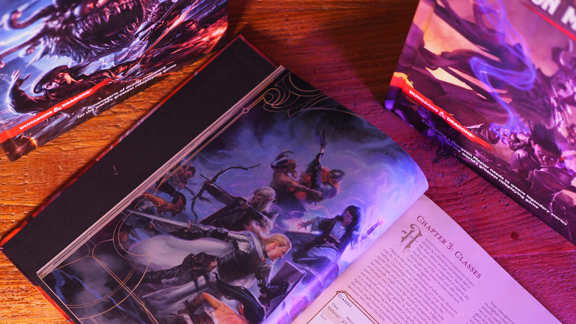 A Player's Handbook lying open at the Classes page on a wooden table, with a Monster Manual and Dungeon Master's Guide on either side