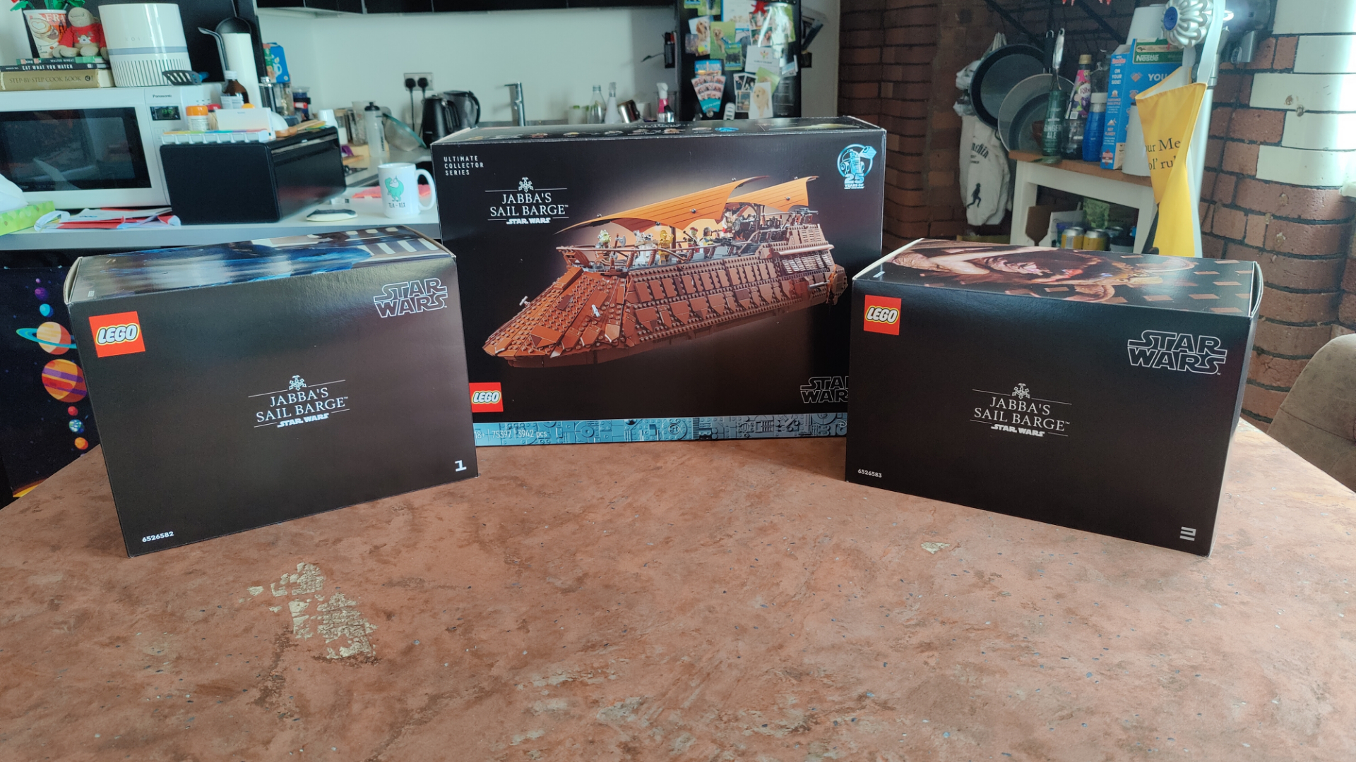 Lego Jabba's Sail Barge boxes laid out on a desert backdrop