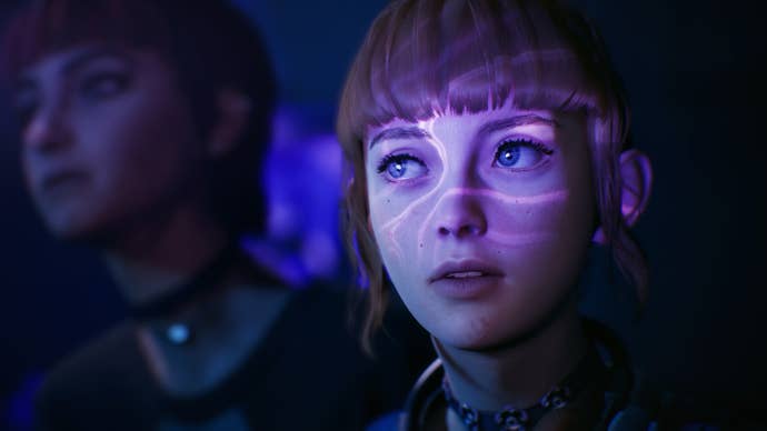 Nora and Kat stare intently at something off-screen that is bathing their faces in purple pulsating light.