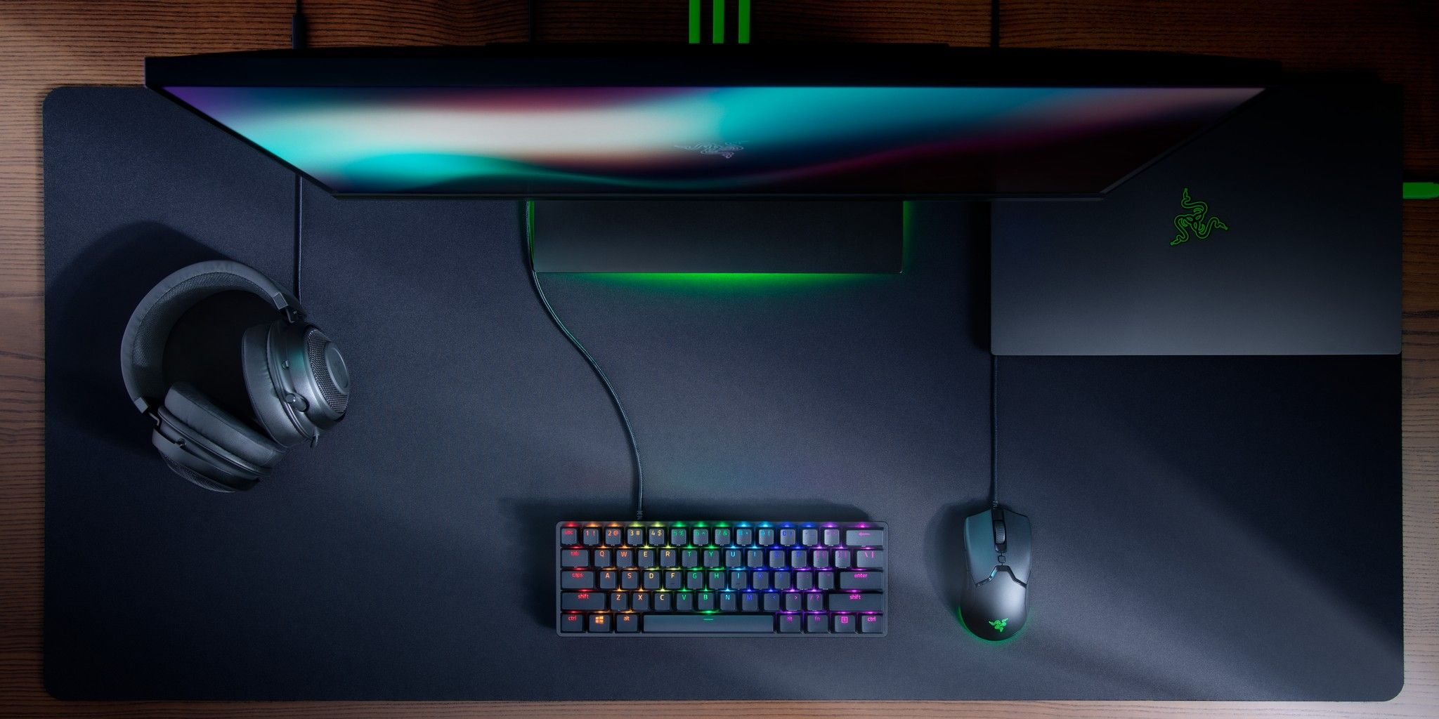 The Razer Huntsman Mini on a desk with a Razer mouse, headset, and monitor.