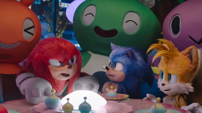 Sonic the Hedgehog 3 trailer screenshot showing Knuckles Sonic and Tails sat in a Chao-themed cafe