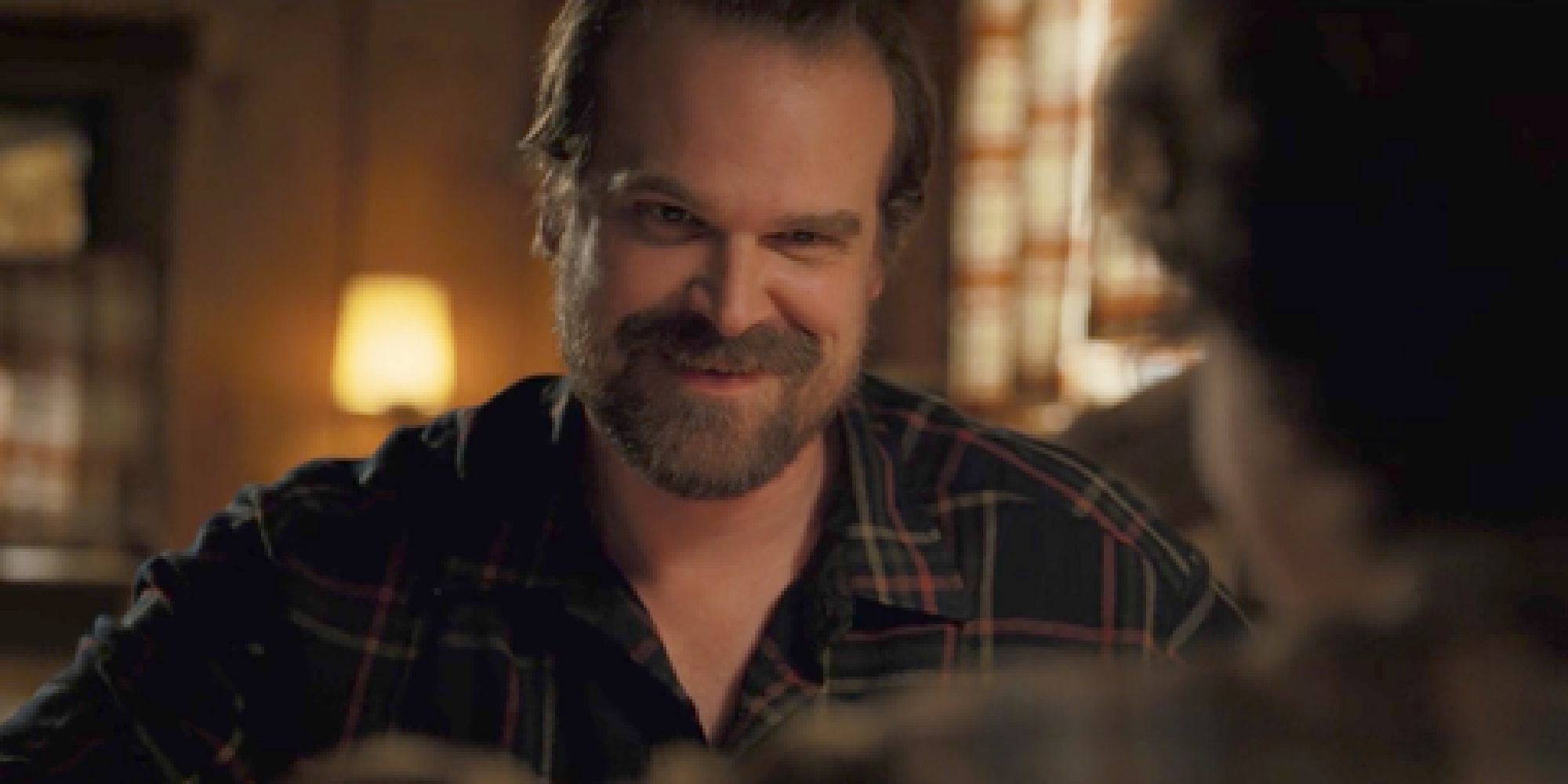 Hopper smiling at Eleven while eating breakfast on Stranger Things