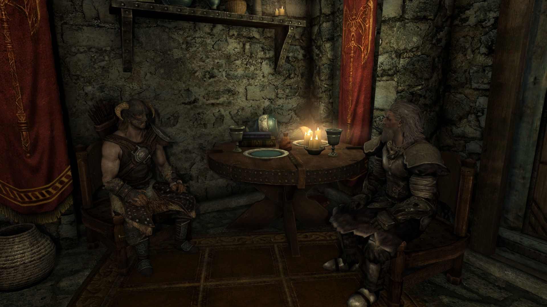 Two men talk in a a rustic home in Skyrim.