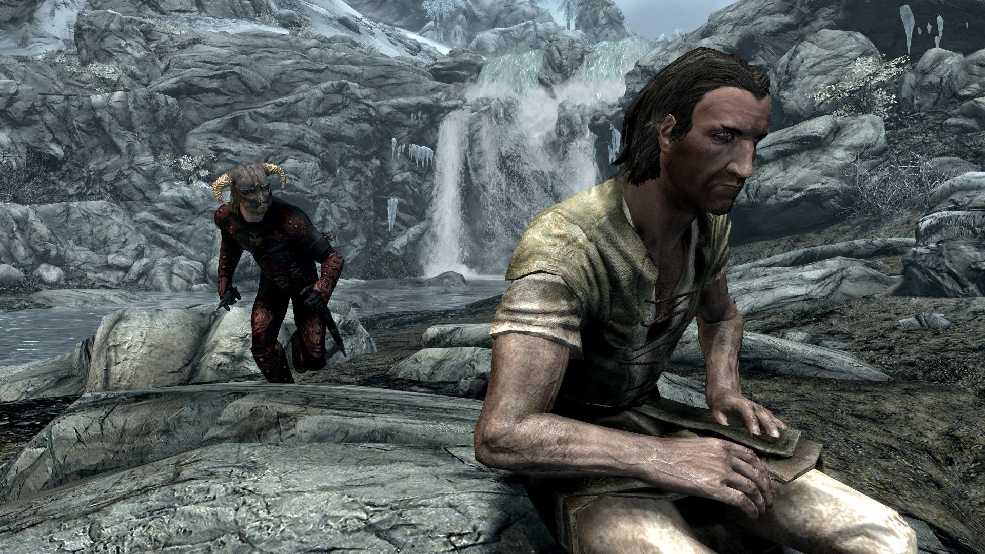 A man sneaks up behind a man sitting on a log in a snowy wilderness in Skyrim.