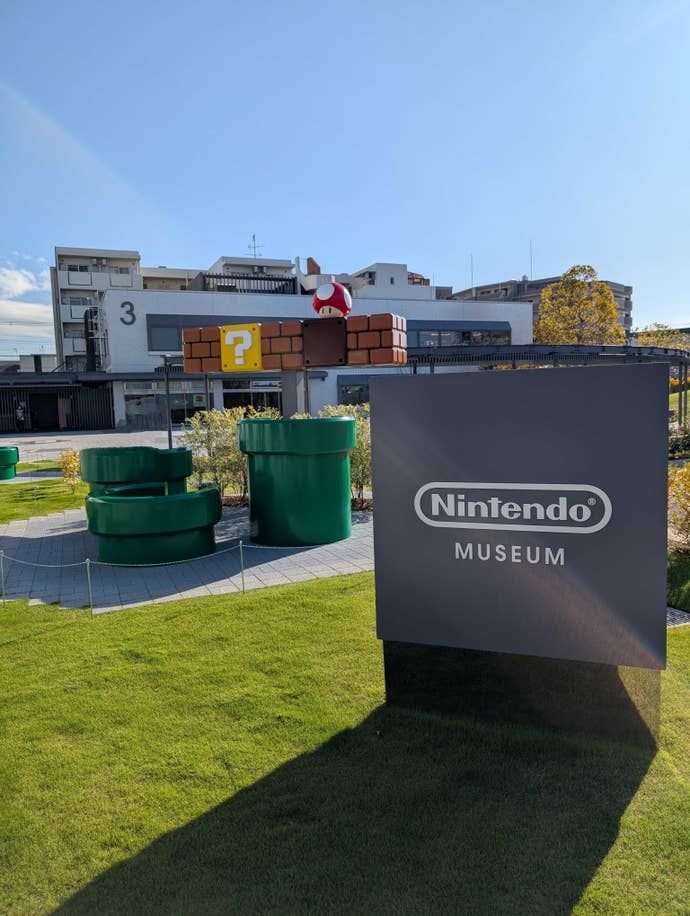 A Nintendo sign and life-size green 'Mario pipes' in the Nintendo Museum.