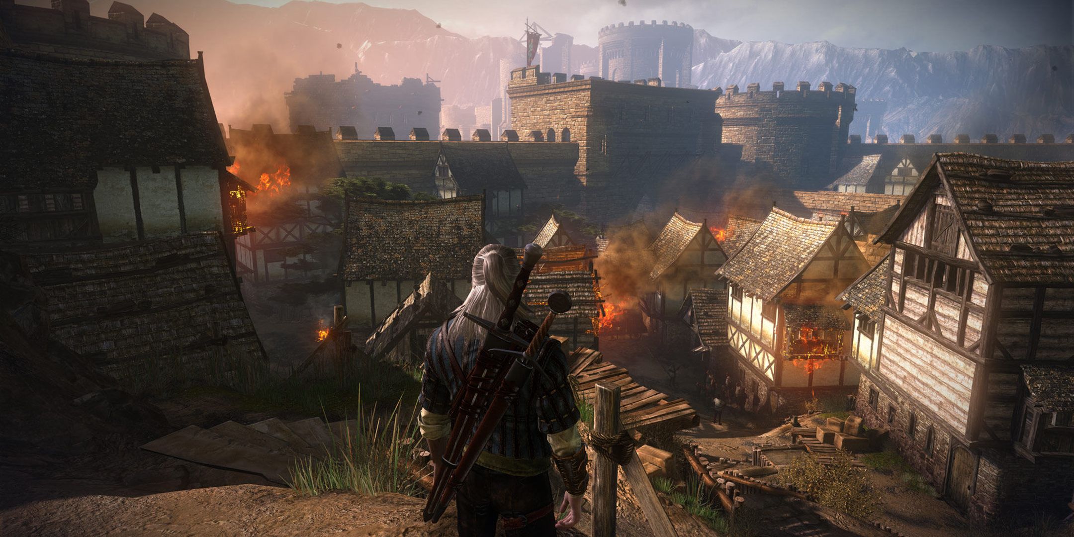 The Witcher 2 screenshot of Geralt overlooking a burning town.