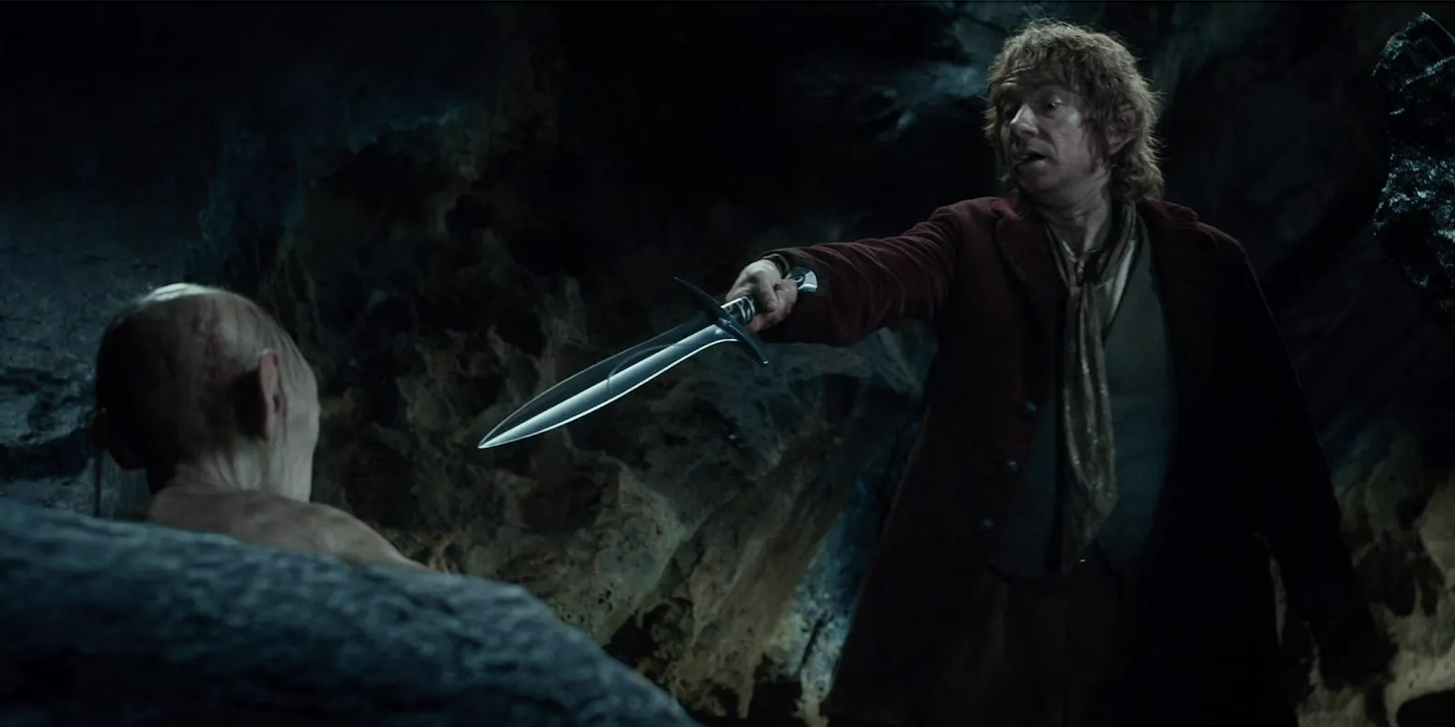 Bilbo points a sword at Gollum in The Hobbit