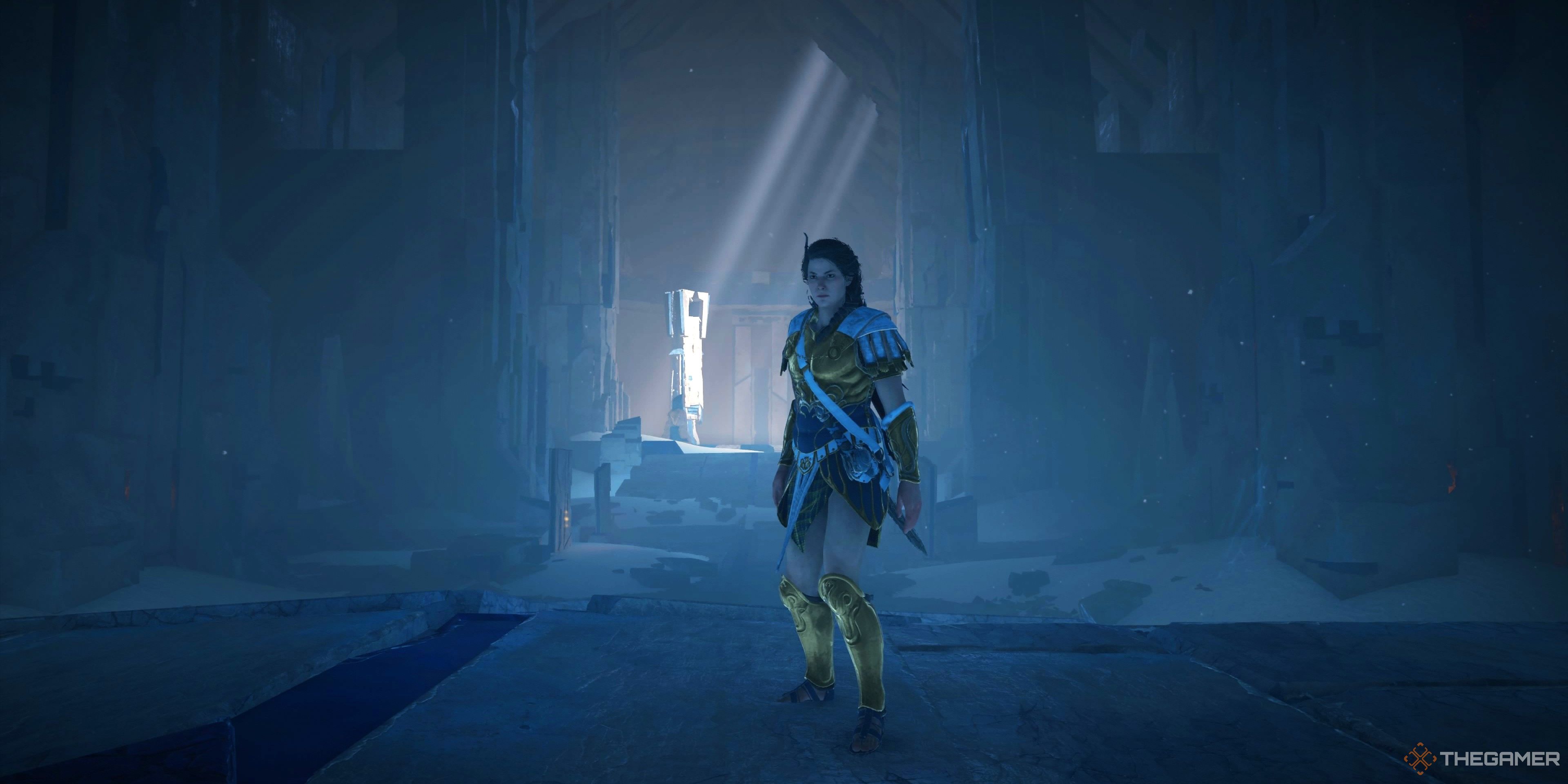 Kassandra standing in the Ancient Forge with light beams raining down behind her in the background from a crack in the forge. She is standing in golden armor and a pillar in the background is the central focus of the image. Concrete looking walls surround the area in an overpowering way.