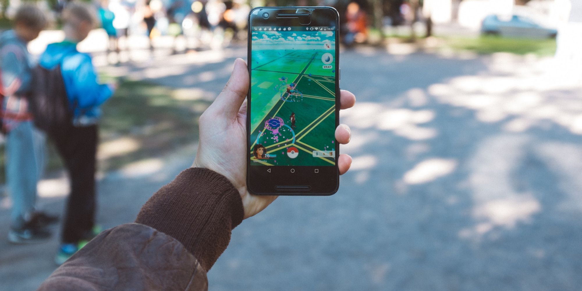 Hand holding phone playing Pokemon Go