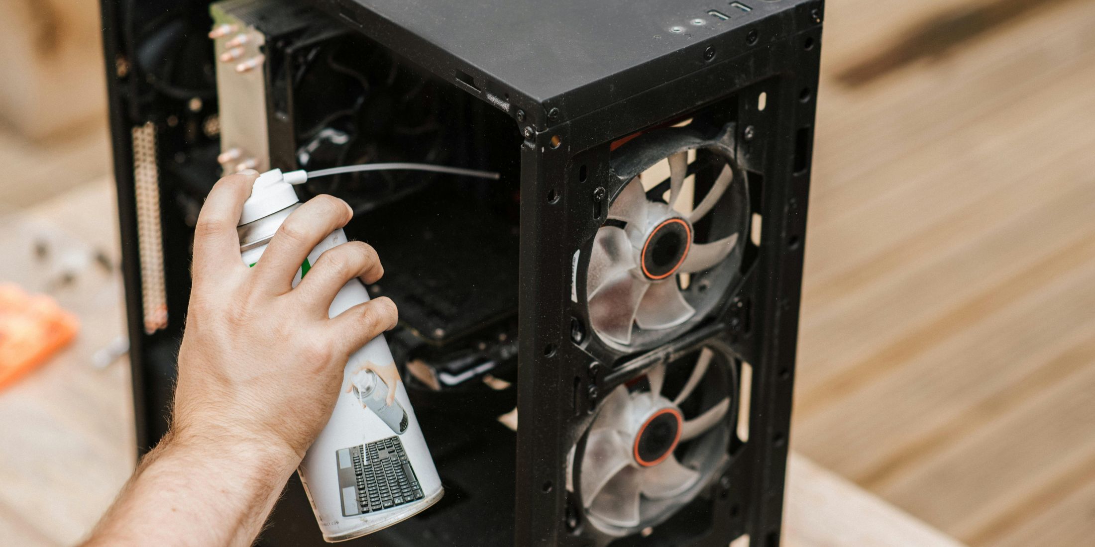 Generic stock image of a PC being repaired with a WD40-like spray.