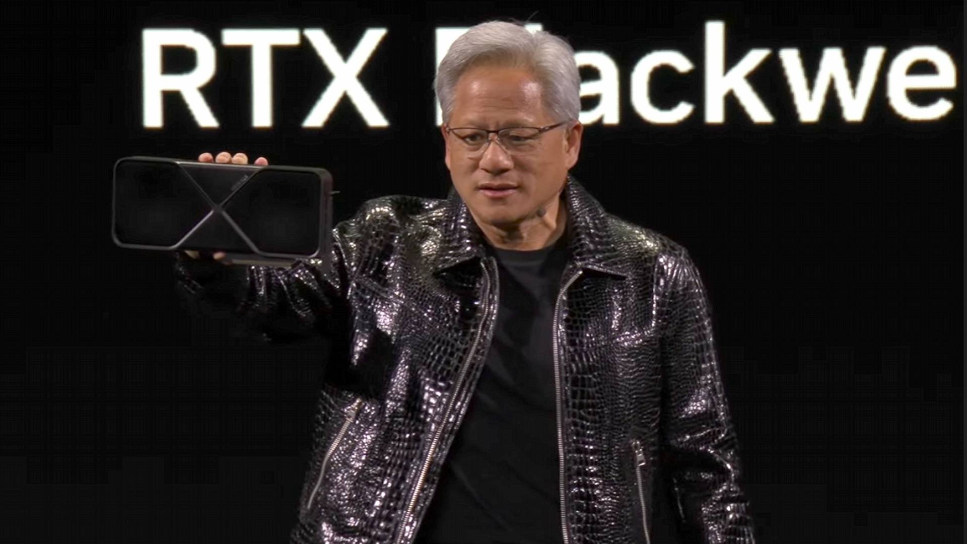 Nvidia CEO Jensen Huang standing on stage holding GeForce RTX 5090 graphics card