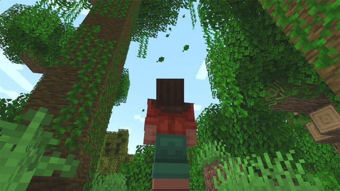 A Minecraft screenshot showing leaves falling from the trees in a forest biome.