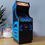 Quartercade Taito Bubble Bobble arcade machine with marquee illuminated sitting on woodgrain surface