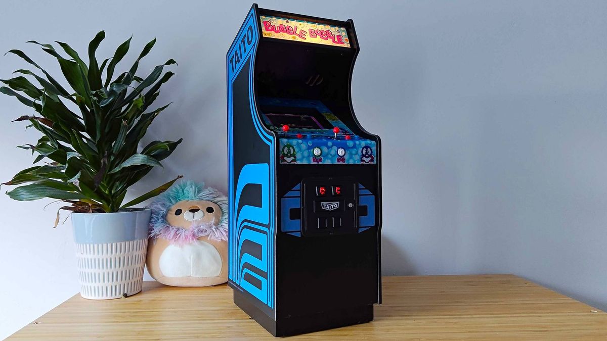 Quartercade Taito Bubble Bobble arcade machine with marquee illuminated sitting on woodgrain surface