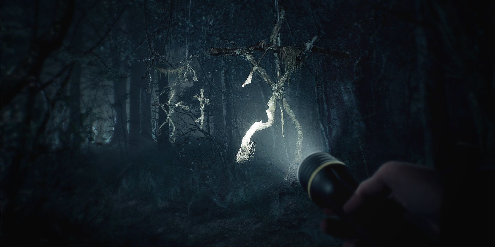 Blair Witch: Shining torch light on wooden witch talismans.