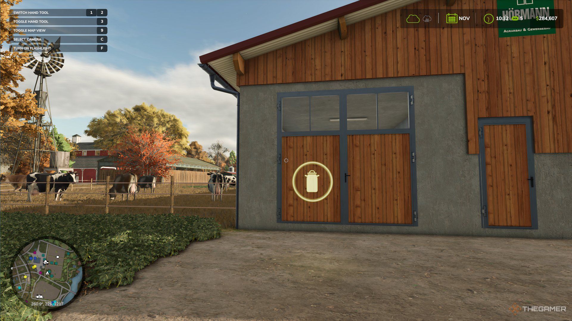 Floating milk canister logo in front of a Cow Barn in Farming Simulator 25.