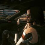 Cyberpunk 2077 screenshot showing Johnny Silverhand sitting the passenger seat of V's car