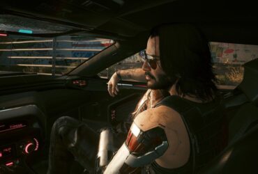 Cyberpunk 2077 screenshot showing Johnny Silverhand sitting the passenger seat of V's car