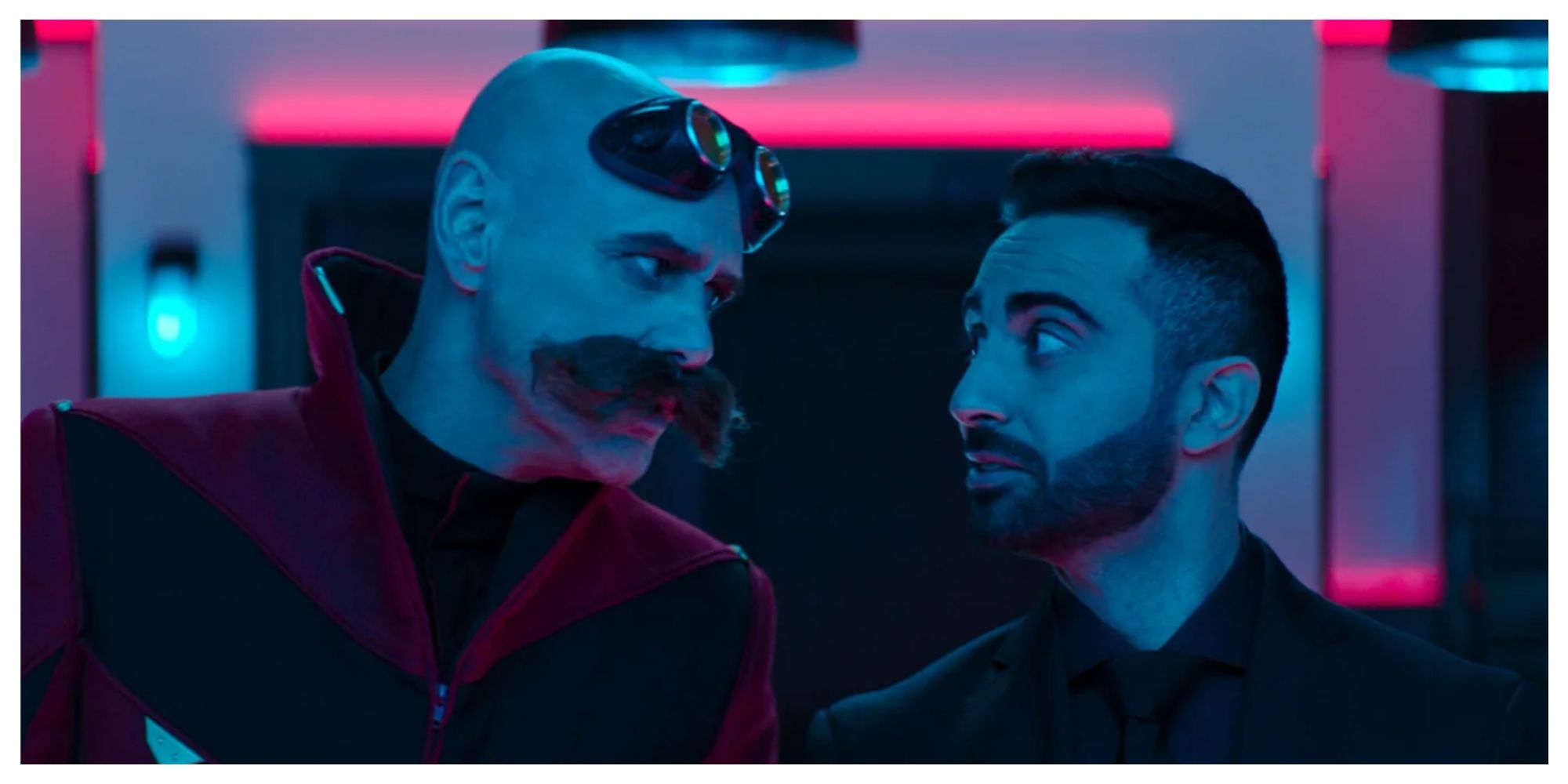 Robotnik (Jim Carrey) and Agent Stone (Lee Majdoub) staring at eachother in Sonic