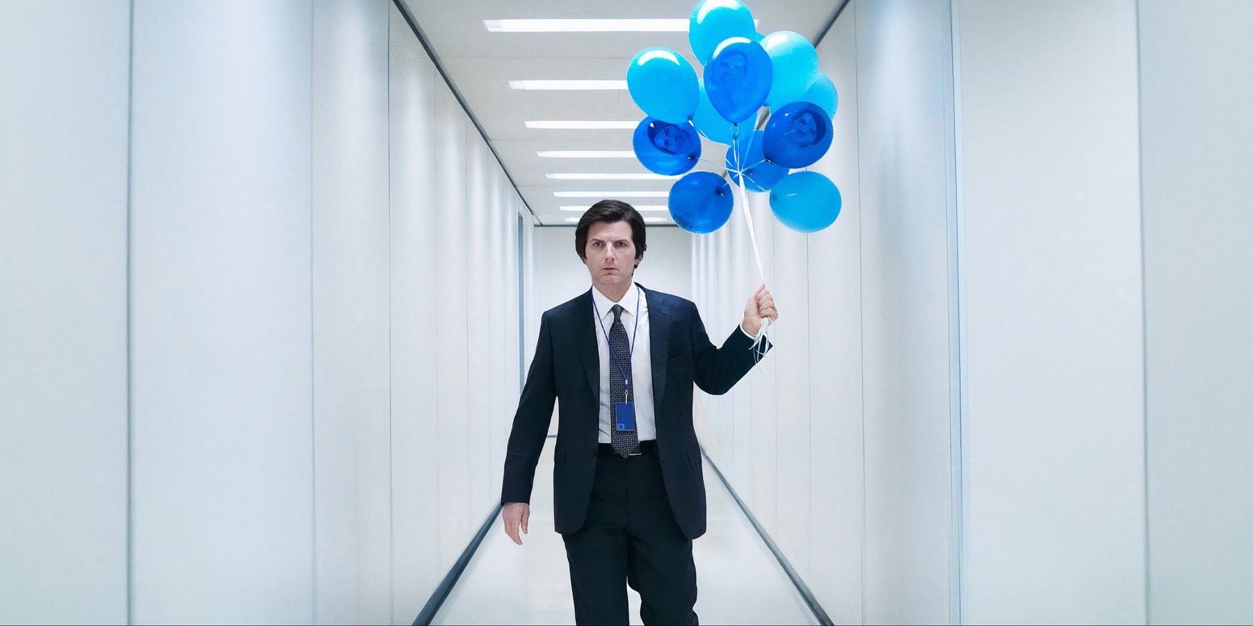 Mark (Adam Scott) holds balloons with his own face on them in Severance season two