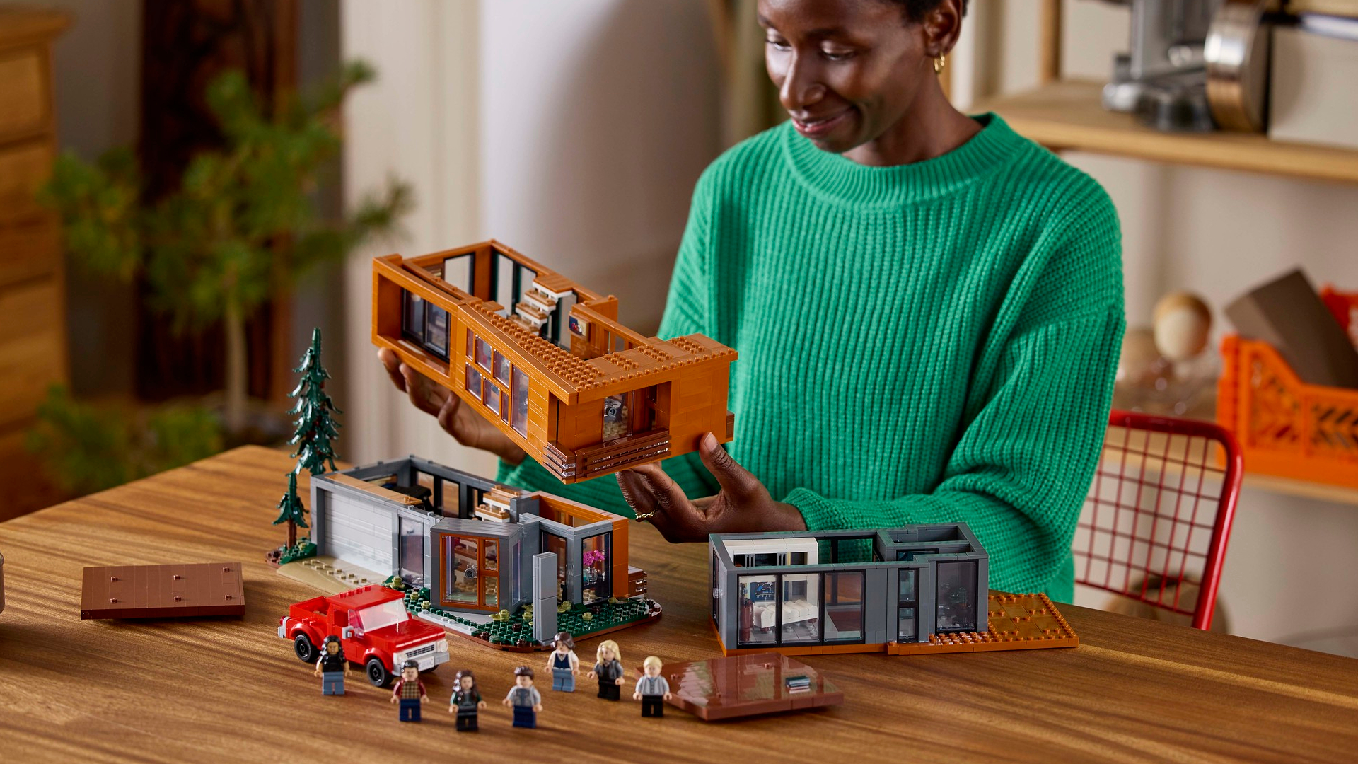 A woman constructs the Lego Twilight set while sat at a wooden table