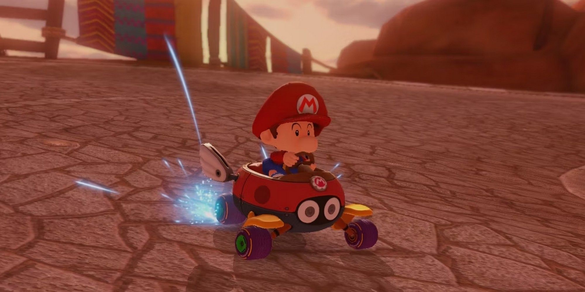 Baby Mario in a small, red kart in Mario Kart 8. 