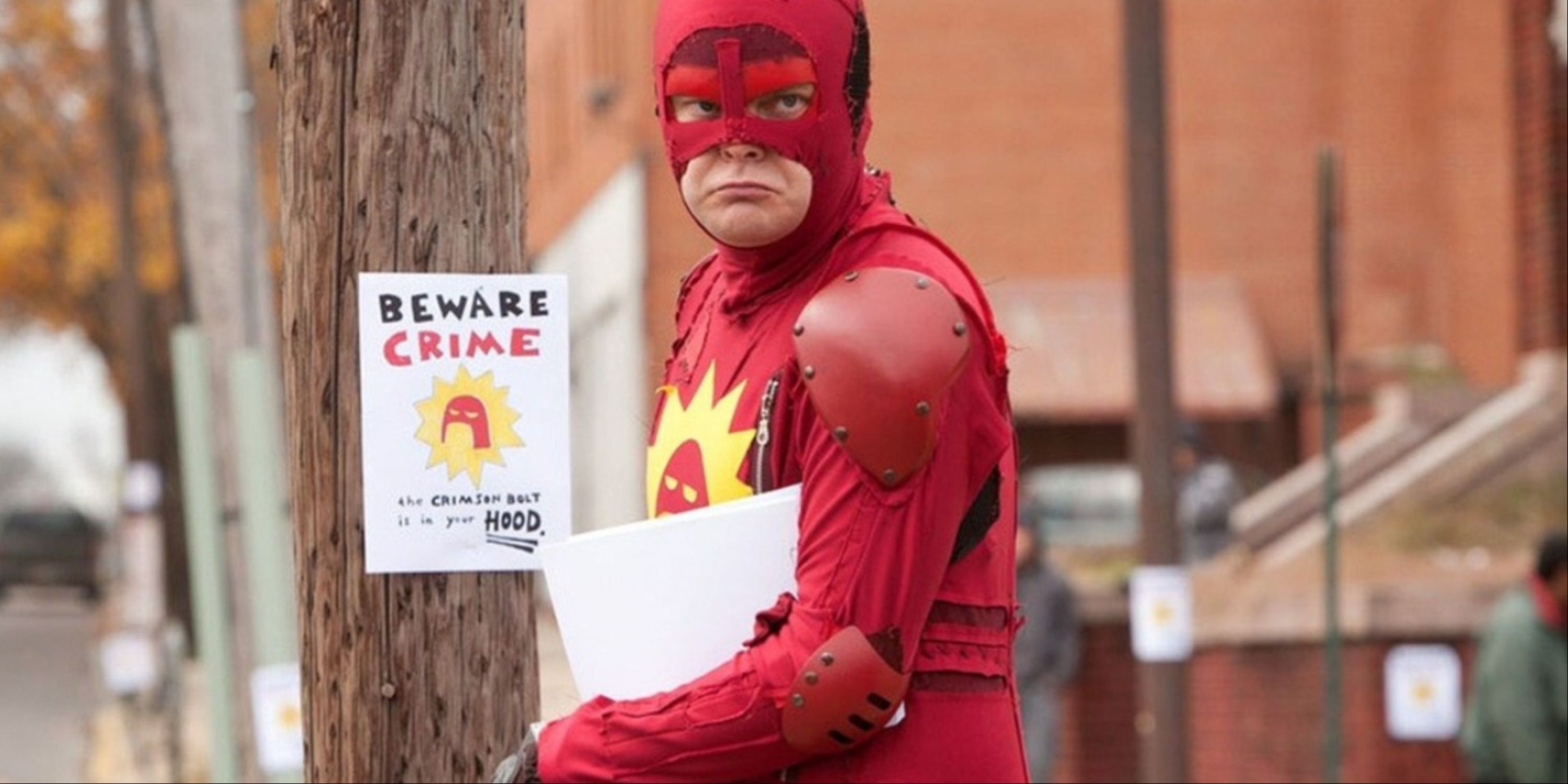 Rainn Wilson as the Crimson Bolt putting up signs in a neighborhood in James Gunn's Super.