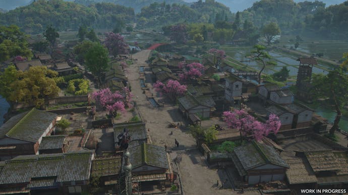 Naoe surveys the castle town of Himeji from a viewpoint, revealing the town below and rice fields in the distance, in Assassin's Creed Shadows.