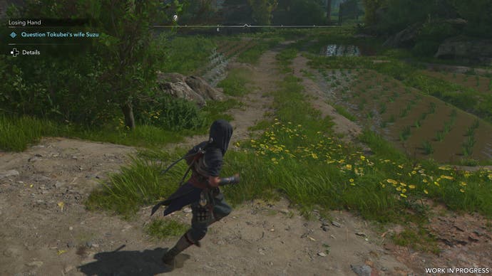 Naoe runs past a rice field in the spring time in Assassin's Creed Shadows. The water is clearly visible in the field.