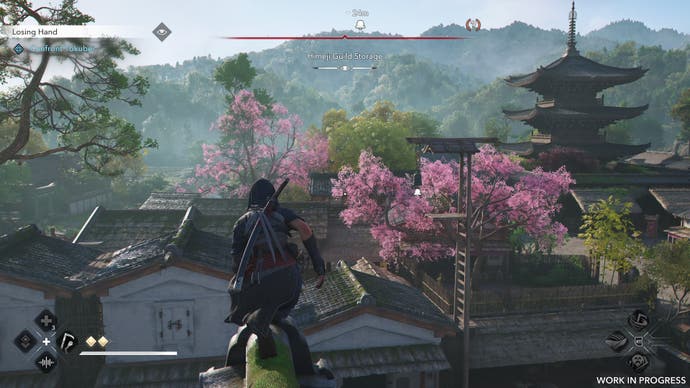 Naoe perches on a rooftop looking at an alarm bell in Assassin's Creed Shadows.