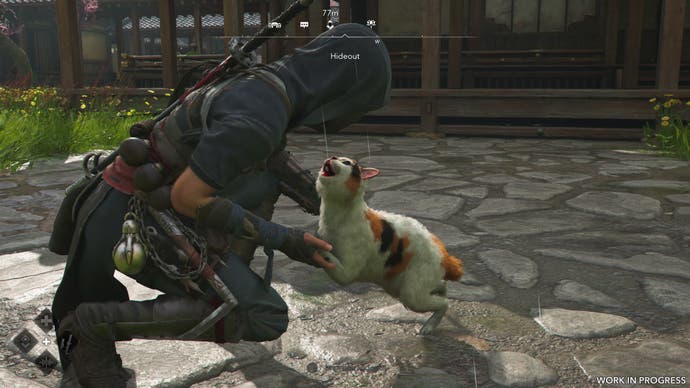 A female shinobi pets a cat in Assassin's Creed Shadows.