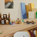 A collection of Lego Minecraft minifigures and scenery laid out on a wooden table