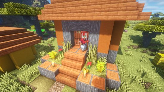 A Minecraft librarian villager stands outside his home in a savannah Minecraft village