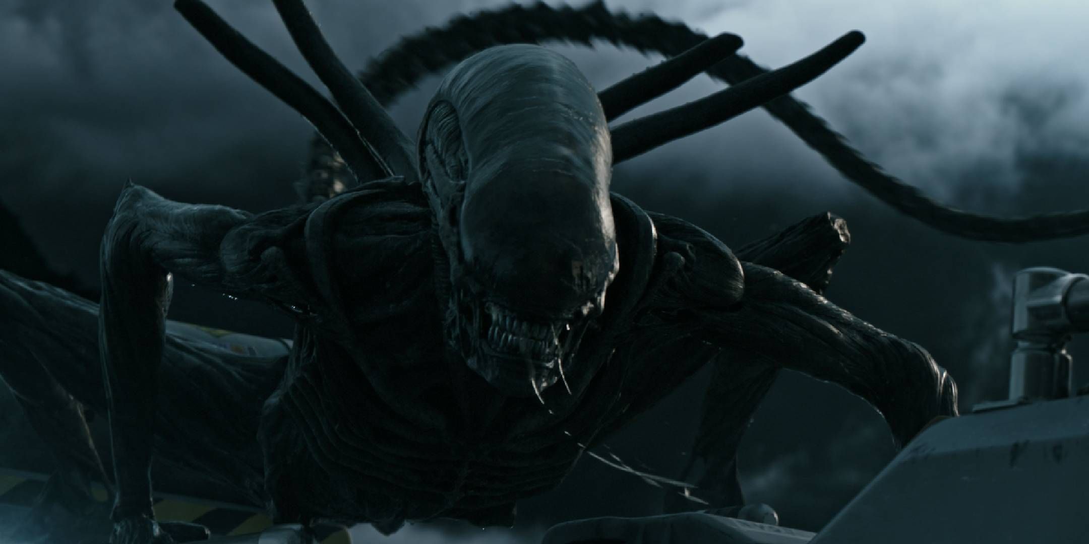 A screen shot from Alien Covenant of a xenomorph landing on a vehicle.