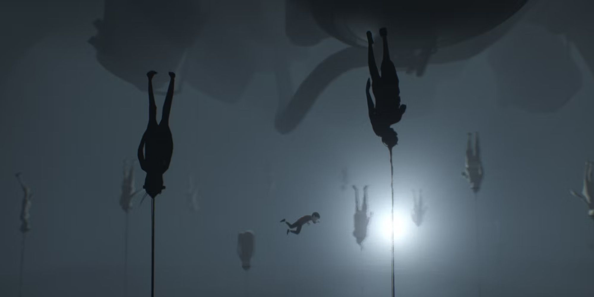 A screenshot from Inside, feautring the boy swims through water filled with tethered bodies.