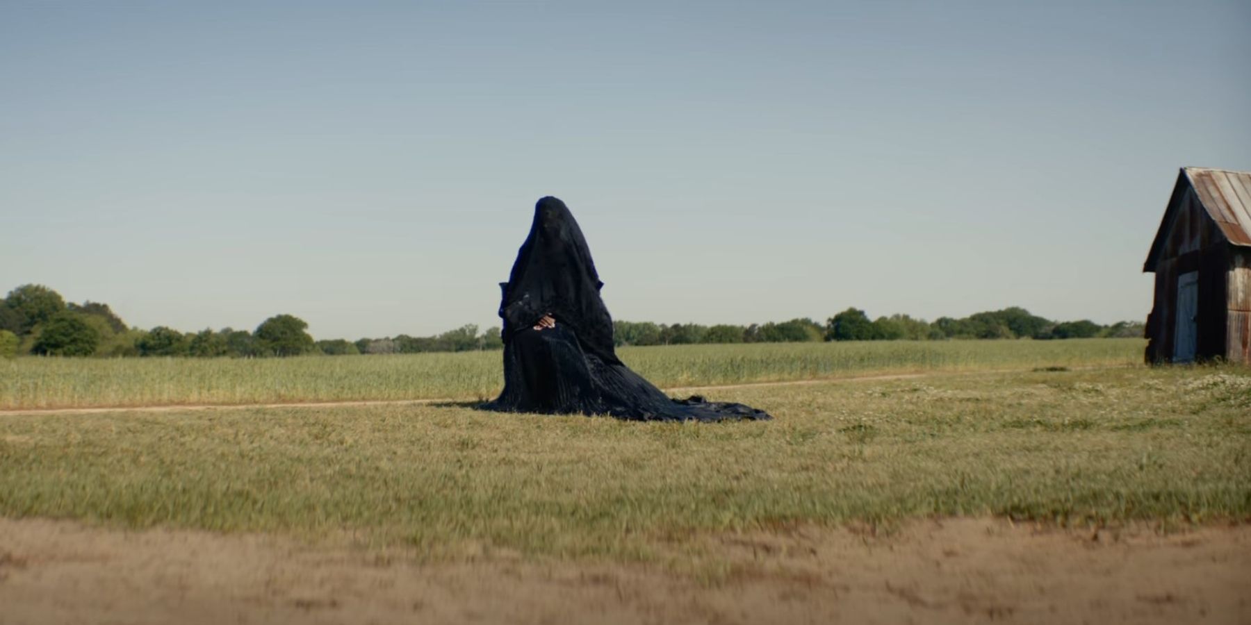 A woman in a black cape in The Woman in the Yard