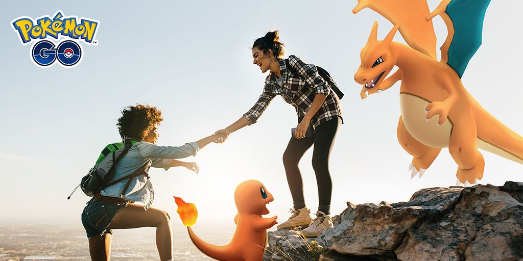 One person helping another climbing up a cliff, one with a Charmander, one with a Charizard.