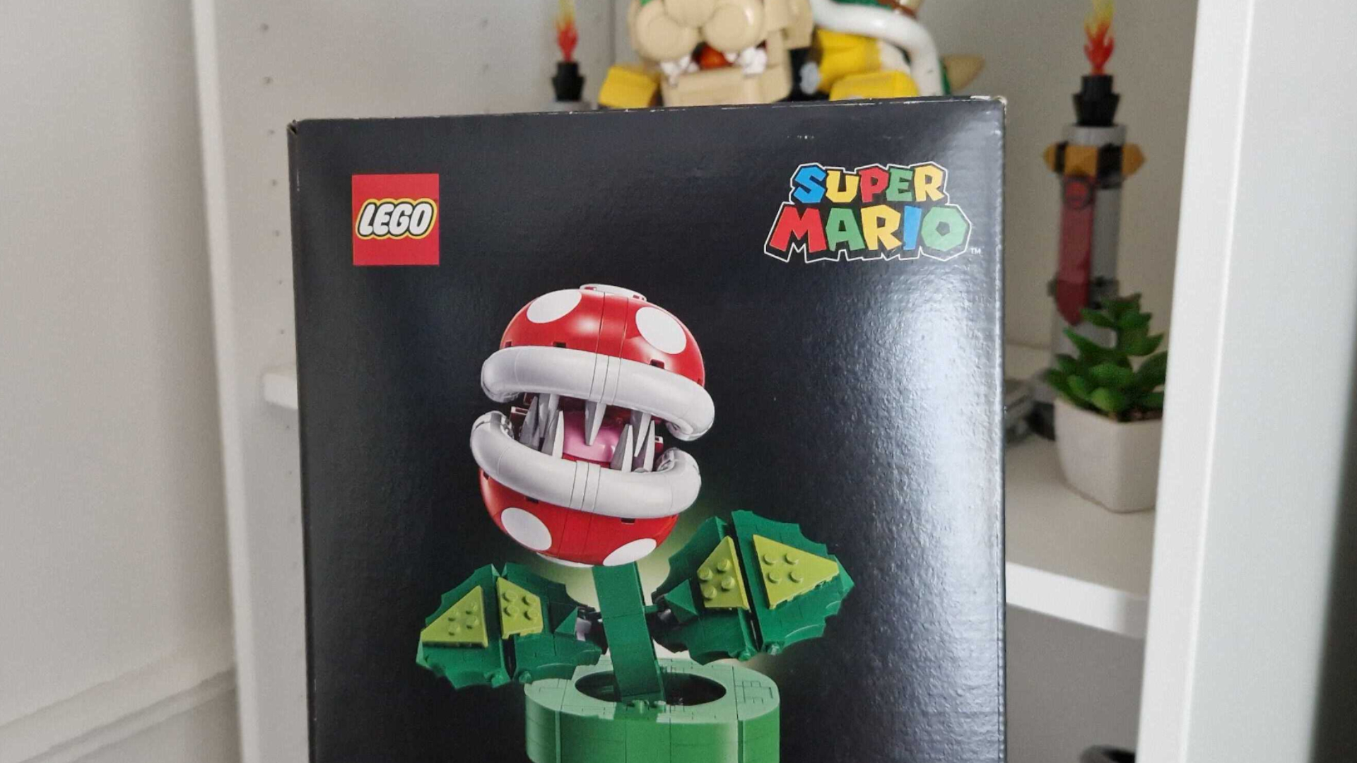 Lego Piranha Plant box in front of white shelving and The Mighty Bowser set