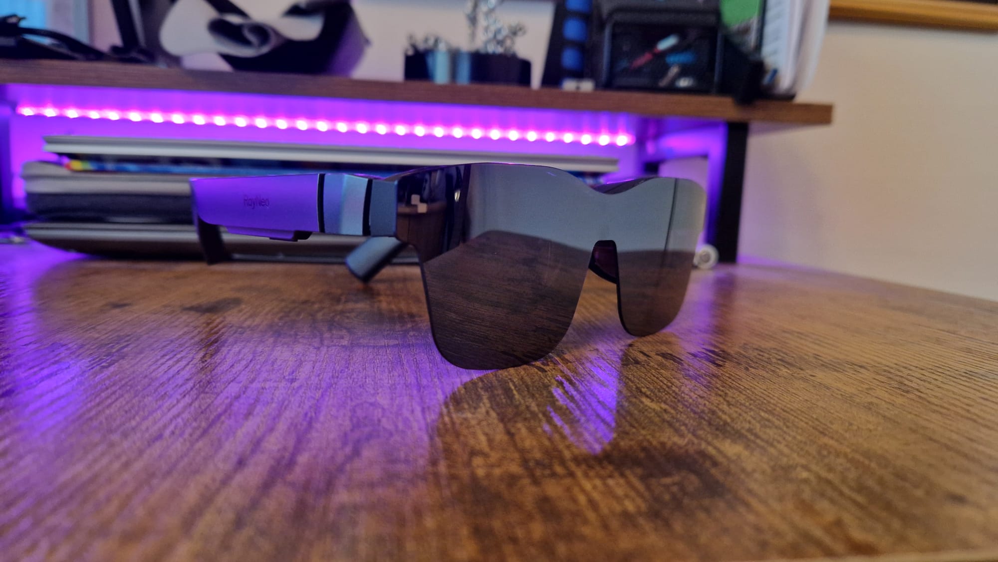 The RayNeo Air 2 XR glasses lying on a walnut desk