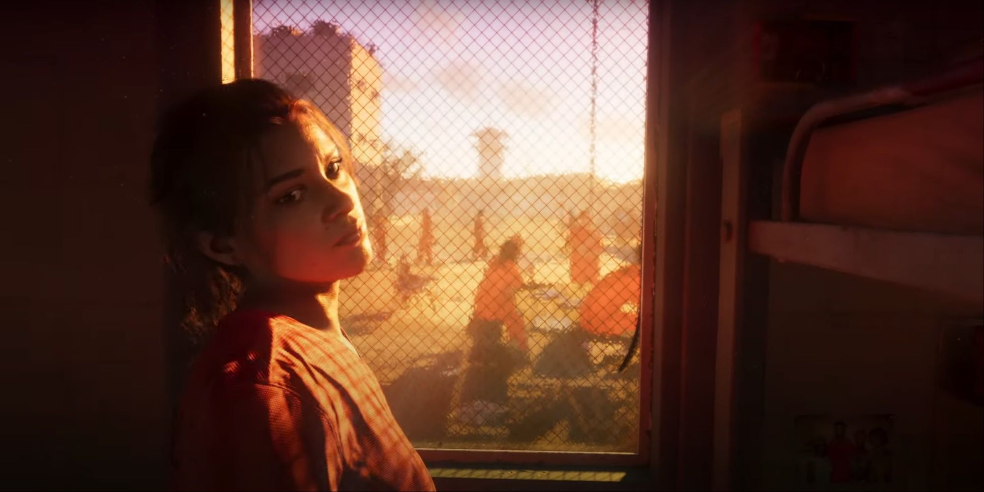 Lucia leaning by the window in her cell looking toward the camera, other inmates socializing on the prison yard is visible through the window.