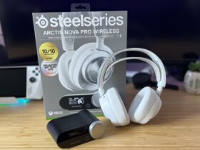 SteelSeries Arctis Nova Pro Wireless in white with packaging and hub on a wooden desk