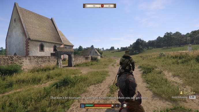 Henry follows another horse as they pass a building on the side of the road in Kingdom Come Deliverance 2