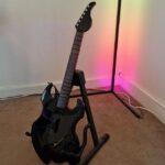 PDP Riffmaster preview image of the guitar on a stand in front of an RGB corner lamp