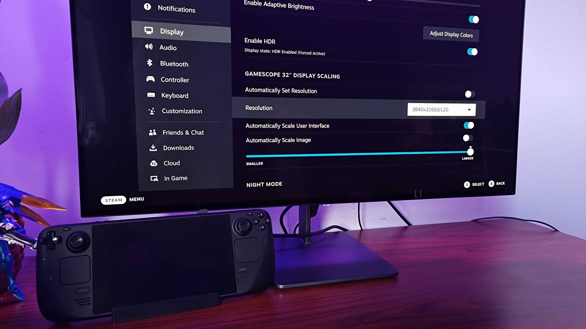 Monitor with SteamOS menu displayed next to Steam Deck and BenQ dock